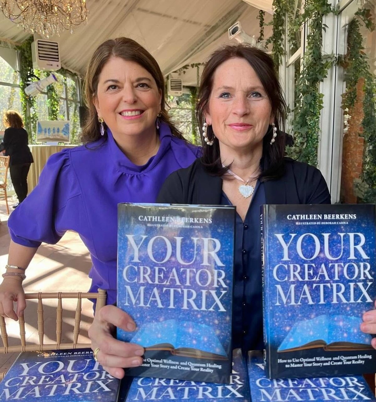 Cathleen Beerkens and a guest displaying copies of Your Creator Matrix